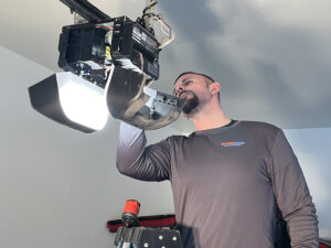 technician examining ceiling mounted motorized opener